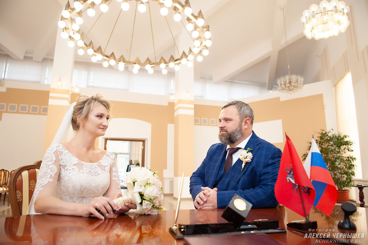 Жених и невеста за столом регистрации Вернадского ЗАГСа