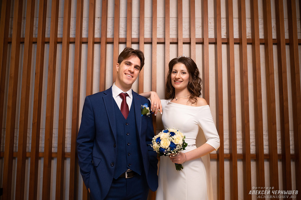 Свадьба в Свиссотель Красные Холмы — фото молодоженов у деревянной стены