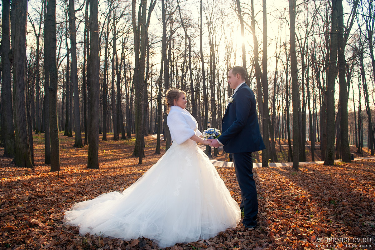 Свадьба в ноябре - жених с невестой держатся за руки, в деревьях