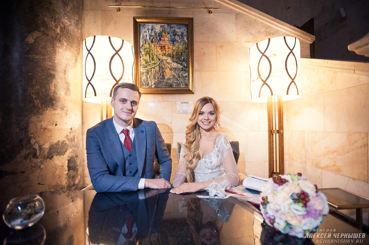 Свадебная фотосессия в Хилтон Ленинградская — фото молодожены сидят за столом
